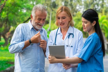 Doktor, hemşire veya parkta caregiver konuşan üst düzey adam. Olgun insanlar sağlık ve tıbbi personel hizmet anlayışı.