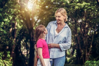 Rahat mutlu anne ve küçük çocuk kız açık havada genel Park. Ebeveyn ve çocuk kavramı.
