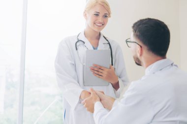 El sıkışma başarı ve profesyonel sağlık personeli ekip çalışması gösteren başka bir doktora veren hastanede doktor.