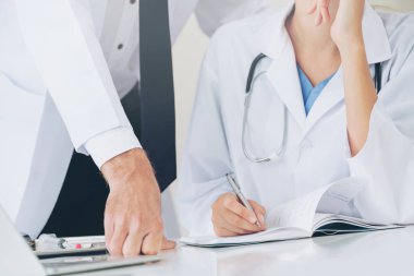 Doktor hastane ofis notlar hastalar raporda başka bir doktor ile konuşma yaparken o ayakta yanında yazıyor.