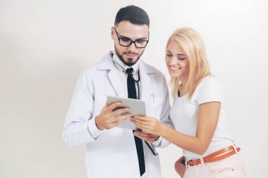 Erkek doktor ve Bayan hasta sağlık veri kaydı için tablet bilgisayar bakıyor. Sağlık ve tıbbi hizmet.