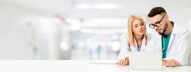 Doktor hastanede başka bir doktor ile bir tartışma yaparken ofiste dizüstü bilgisayarla çalışma. Tıbbi sağlık ve doktor hizmeti.