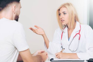 Kadın doktor hastane office erkek hastada konuşuyor. Sağlık ve tıbbi hizmet.