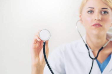 Genç kadın doktor işaretleme stetoskop boş alan. Seçici odak doktorlar el at. Tıbbi sağlık kavramı.