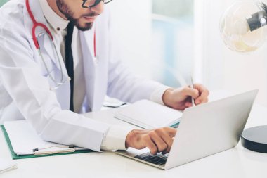 Doktor hastanede Ofis masaları, dizüstü bilgisayar üzerinde çalışıyor. Tıbbi ve sağlık kavramı.