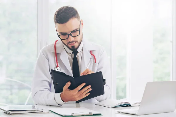 Doctor Leyendo Mientras Escribe Una Nota Libro Oficina Hospital Concepto — Foto de Stock