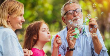 Mutlu aile sabun köpüğü birlikte tatil hafta sonu Bahçe parkta yaz aylarında giderken darbeler. Çocuk eğitim ve aile etkinlikleri kavramı.