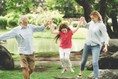 Sağlıklı etkin baba ve anne parkta kapma ve yaz hafta sonu kız çocuk ile oynamak. Aktif kıdemli ve aile yaşam tarzı kavramı.