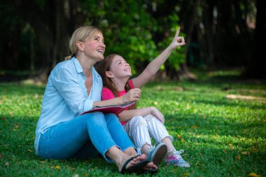 Rahat mutlu anne ve küçük çocuk kız açık havada genel Park. Ebeveyn ve çocuk kavramı.