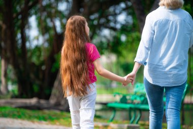 Rahat mutlu anne ve küçük çocuk kız açık havada genel Park. Ebeveyn ve çocuk kavramı.