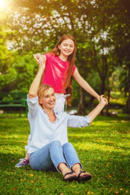 Rahat mutlu anne ve küçük çocuk kız açık havada genel Park. Ebeveyn ve çocuk kavramı.