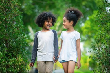Mutlu erkek ve kız parkta. İki Afro-Amerikan çocuk birlikte bahçede.
