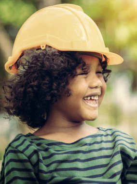 Sarı Emanet kask kask giyiyor ve mutluluktan gülerek mutlu küçük çocuk mühendis. Eğitim ve kavram öğrenme.