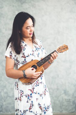 Ukulele oynama ve ses stüdyosunda bir şarkı söylerken mutlu kadın müzisyen. Müzik yaşam tarzı konsepti.