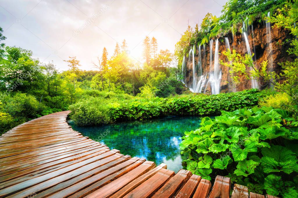 Beautiful wooden path trail for nature trekking with lakes and waterfall landscape in Plitvice Lakes National Park, UNESCO natural world heritage and famous travel destination of Croatia.