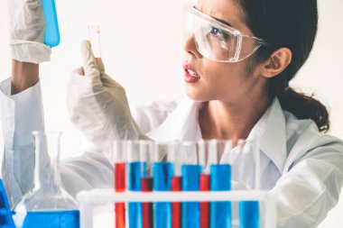 Laboratuvarda çalışan ve deney tüpündeki biyokimya örneklerini inceleyen kadın bilim adamı. Bilim teknolojisi araştırma ve geliştirme konsepti.