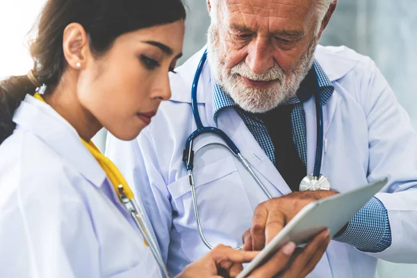 의사는 병원에서 의사와 하면서 태블릿 컴퓨터를 직원과 서비스 — 스톡 사진