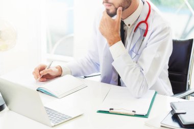 Doktor hastanede Ofis masaları, dizüstü bilgisayar üzerinde çalışıyor. Tıbbi ve sağlık kavramı.