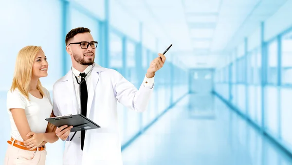 Doctor with patient pointing at empty copy space for your text. The happy patient is listening to explanation from the doctor. Concept of medical healthcare and doctor staff service.