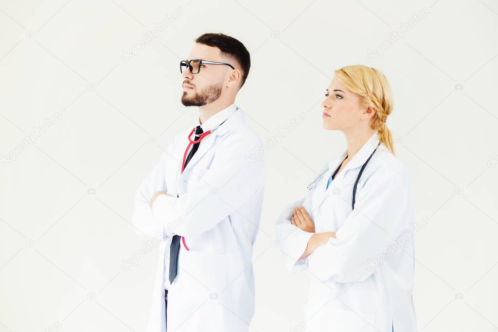 Confident doctors standing on white background with arms crossed. Concept of professional medical healthcare team.