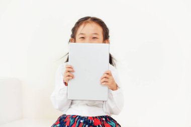 Tablet bilgisayar ile beyaz arka plan üzerinde küçük mutlu çocuk. Çocukluk yaşam tarzı.