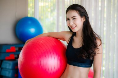 Güzel genç kadın fitness Center'da fitness topu ile pilates egzersiz yapmak. Sağlıklı yaşam konsepti.
