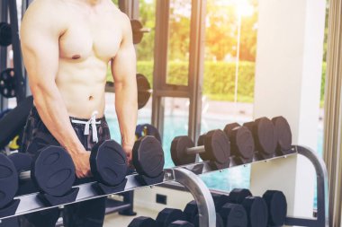 Kaslı adam vücut fitness spor salonu Eğitim dumbbells ile. Sağlıklı yaşam tarzı ve vücut geliştirme kavramı.
