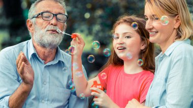 Mutlu aile sabun köpüğü birlikte tatil hafta sonu Bahçe parkta yaz aylarında giderken darbeler. Çocuk eğitim ve aile etkinlikleri kavramı.
