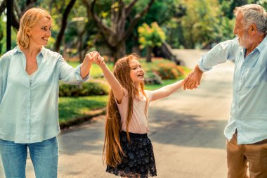 Mutlu sağlıklı aile yürümek birlikte parkta yolda yaz aylarında. Aile bağ kavramı.