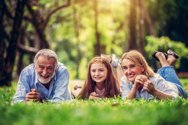 Mutlu bir aile birlikte parkta yaz aylarında rahatlatıcı. Aile bağı ve ilişkisi kavramı.