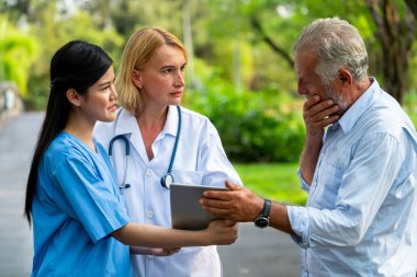 Senior man talking to doctor, nurse or caregiver in the park. Mature people healthcare and medical staff service concept. clipart