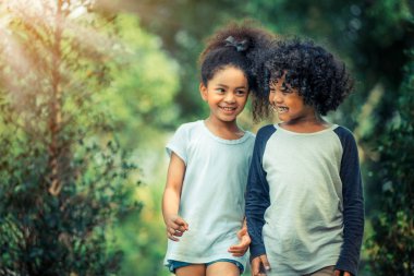 Mutlu erkek ve kız parkta. İki Afro-Amerikan çocuk birlikte bahçede.