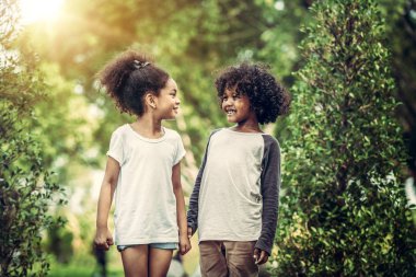 Mutlu erkek ve kız parkta. İki Afro-Amerikan çocuk birlikte bahçede.