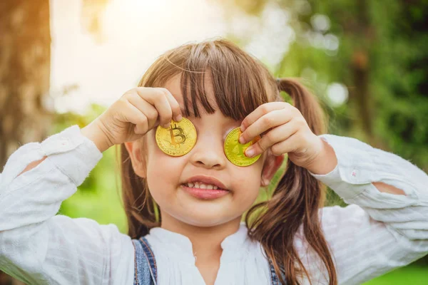 Bitcoin dijital para tutan küçük bir kız çocuk. Yatırım ve ticaret kolay bitcoin kavramı.
