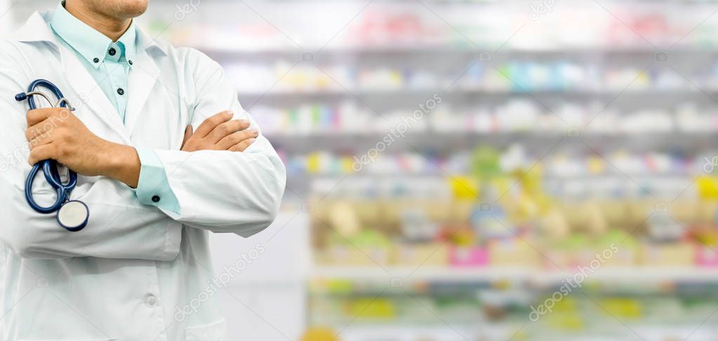 Male pharmacist standing in the drugstore pharmacy. Medical healthcare and pharmaceutical service.