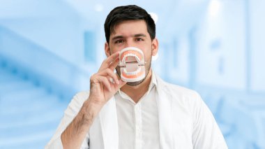 Genç erkek diş hekimi diş kliniğinde çalışıyor. Diş Hekimliği bakım ve tıbbi hizmet anlayışı.