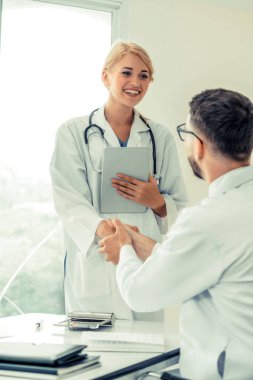 El sıkışma başarı ve profesyonel sağlık personeli ekip çalışması gösteren başka bir doktora veren hastanede doktor.
