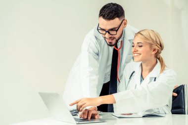 Doktor hastane ofis dizüstü bilgisayar masanın üzerinde başka bir doktor hasta sağlık hakkında tartışma ile çalışma.