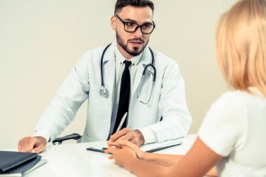 Erkek doktor hastane ofiste bayan hasta konuşuyor. Sağlık ve tıbbi hizmet.