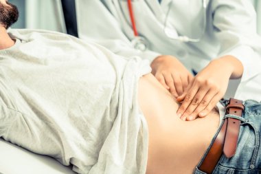 Kadın doktor konuşuyor ve erkek hasta hastane ofisinde inceleyerek. Sağlık ve tıbbi hizmet.