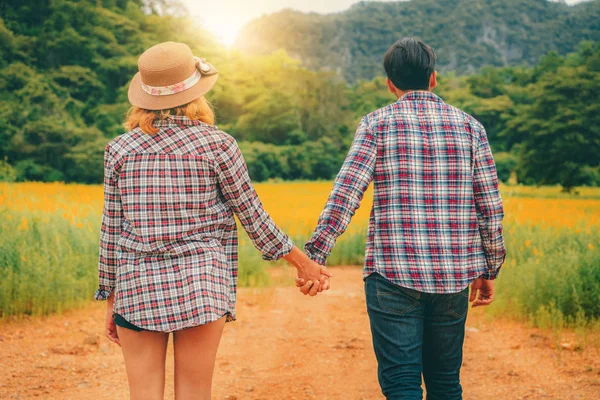 幸せなカップルは 丘の上の緑の芝生のフィールドでロマンチックな散歩を取る 旅行や新婚旅行のコンセプト — ストック写真