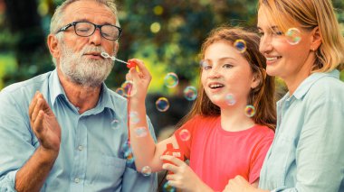 Mutlu aile sabun köpüğü birlikte tatil hafta sonu Bahçe parkta yaz aylarında giderken darbeler. Çocuk eğitim ve aile etkinlikleri kavramı.