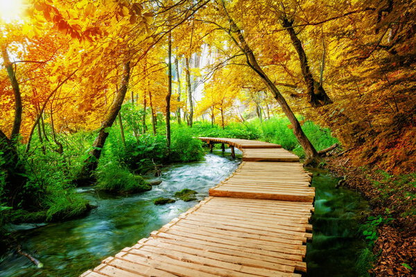 Beautiful wooden path trail for nature trekking with lakes and waterfall landscape in Plitvice Lakes National Park, UNESCO natural world heritage and famous travel destination of Croatia.