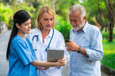 Doktor, hemşire veya parkta caregiver konuşan üst düzey adam. Olgun insanlar sağlık ve tıbbi personel hizmet anlayışı.