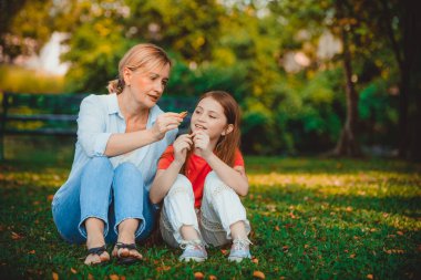 Rahat mutlu anne ve küçük çocuk kız açık havada genel Park. Ebeveyn ve çocuk kavramı.