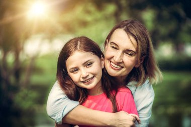 Rahat mutlu anne ve küçük çocuk kız açık havada genel Park. Ebeveyn ve çocuk kavramı.