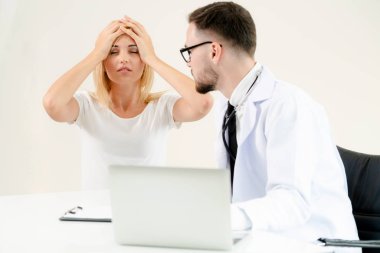 Erkek doktor hastane ofiste bayan hasta masada dizüstü bilgisayarda hastalar sağlık verilere bakarken konuştuğu. Sağlık ve tıbbi hizmet.