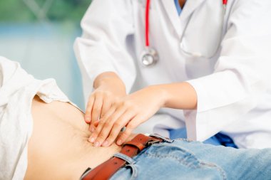 Kadın doktor konuşuyor ve erkek hasta hastane ofisinde inceleyerek. Sağlık ve tıbbi hizmet.