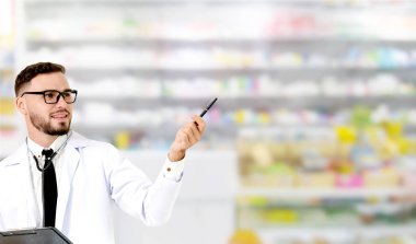 Young male pharmacist pointing at empty copy space for your text in the hospital. Medical healthcare and doctor staff service. clipart