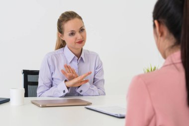 İş başvurusu ve iş anlaşması için ofis masasında toplanan iki genç iş kadını. İşe alım ve insan kaynakları kavramı.